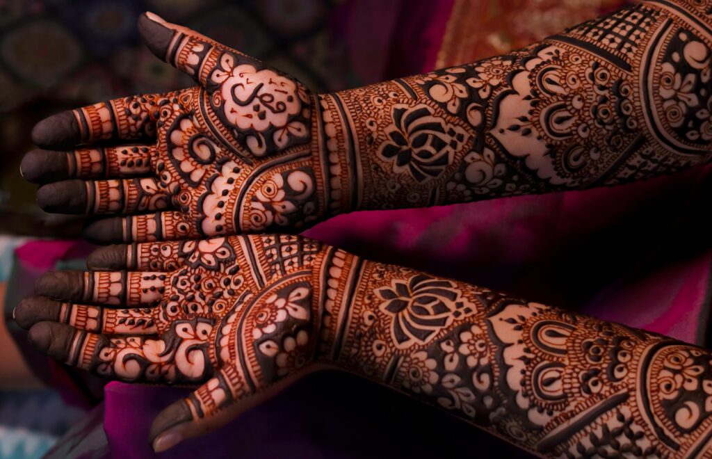 Detailed mehndi art showcasing intricate henna patterns on hands and arms.